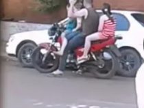 Ganze Familie auf dem Motorrad und der Lenker trinkt Bier