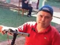Ideenreicher Rollstuhlfahrer mit Skateboard unterwegs